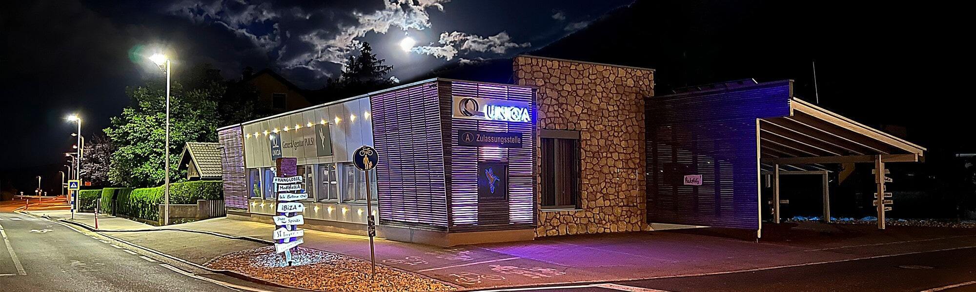Das beleuchtete Gebäude der UNIQA GeneralAgentur PULS bei Nacht.